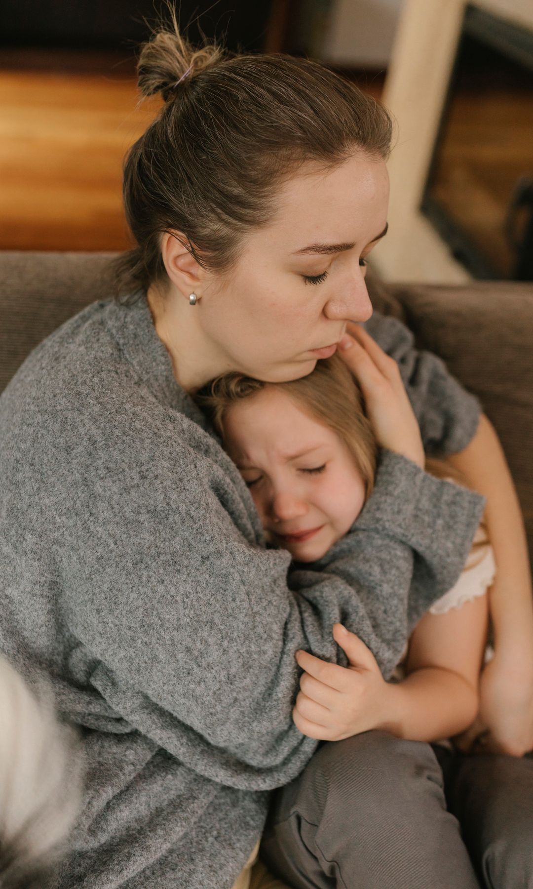 Madre abraza a su hija, triste