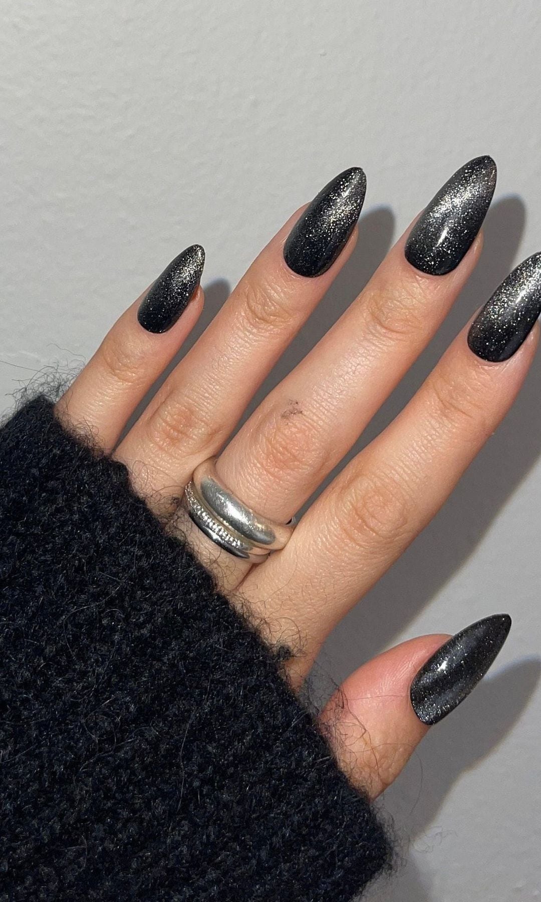 Uñas almendradas con manicura velvet negra de brillo metálico intenso