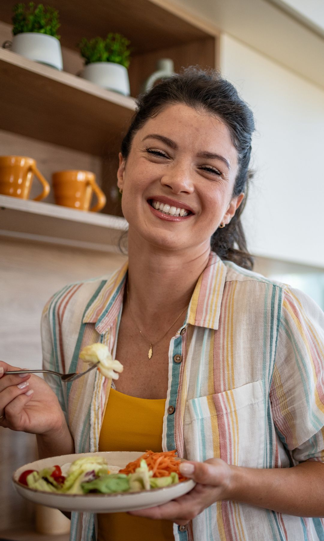 Mujer comiendo sano en la cocina y feliz