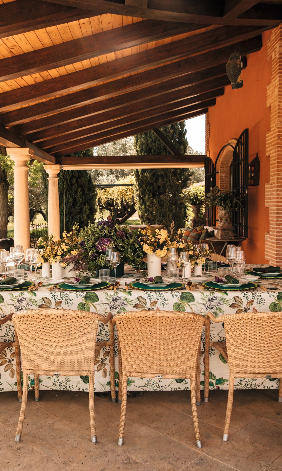 Una gran mesa de comedor en el porche con vistas al jardín y la piscina
