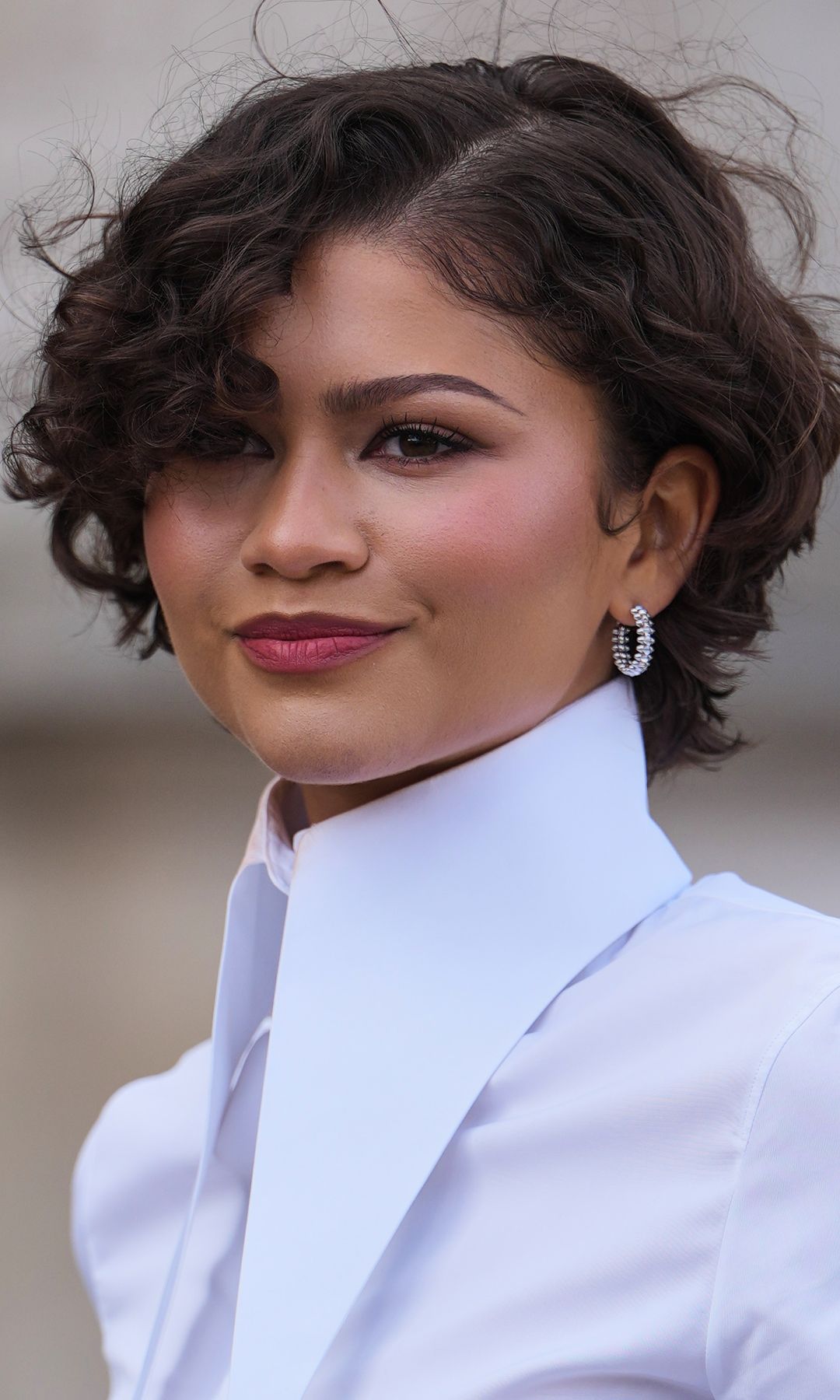 PARIS, FRANCE - MARCH 10: Zendaya Coleman wears earrings, a dark brown bob haircut with side part, red lipstuck, a white shirt with long collar, outside Louis Vuitton, during Paris Fashion Week - Womenswear Fall/Winter 2026/2027, on March 10, 2026 in Paris, France