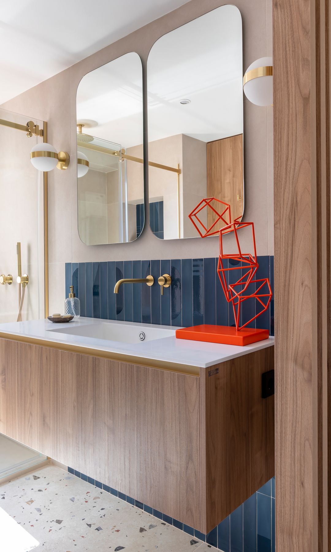 Baño con escultura colorida en el lavabo. Proyecto de Julio Palacios.