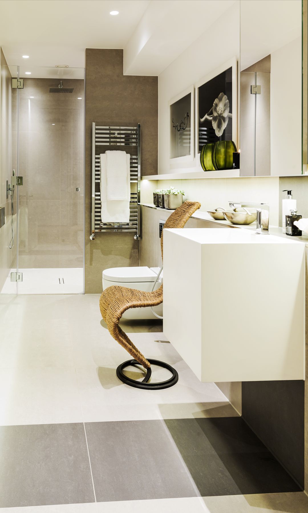 Baño con ducha, con planta en línea, radiador toallero, lavabo integrado en el mueble, cuadros, murete de obra con accesorios, esoejo 