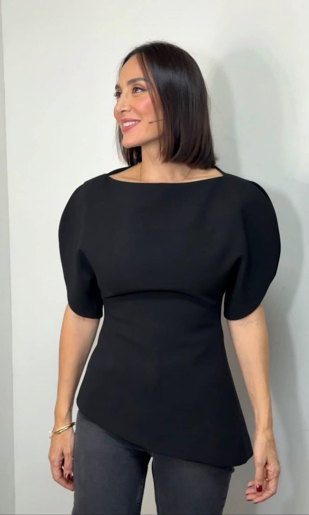 Tamara Falcó con top de mangas abullonadas negro, y vaqueros, de Zara