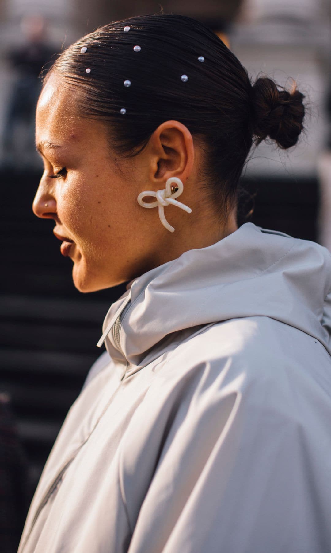 Invitada a la Semana de la Moda con moño decorado con perlas