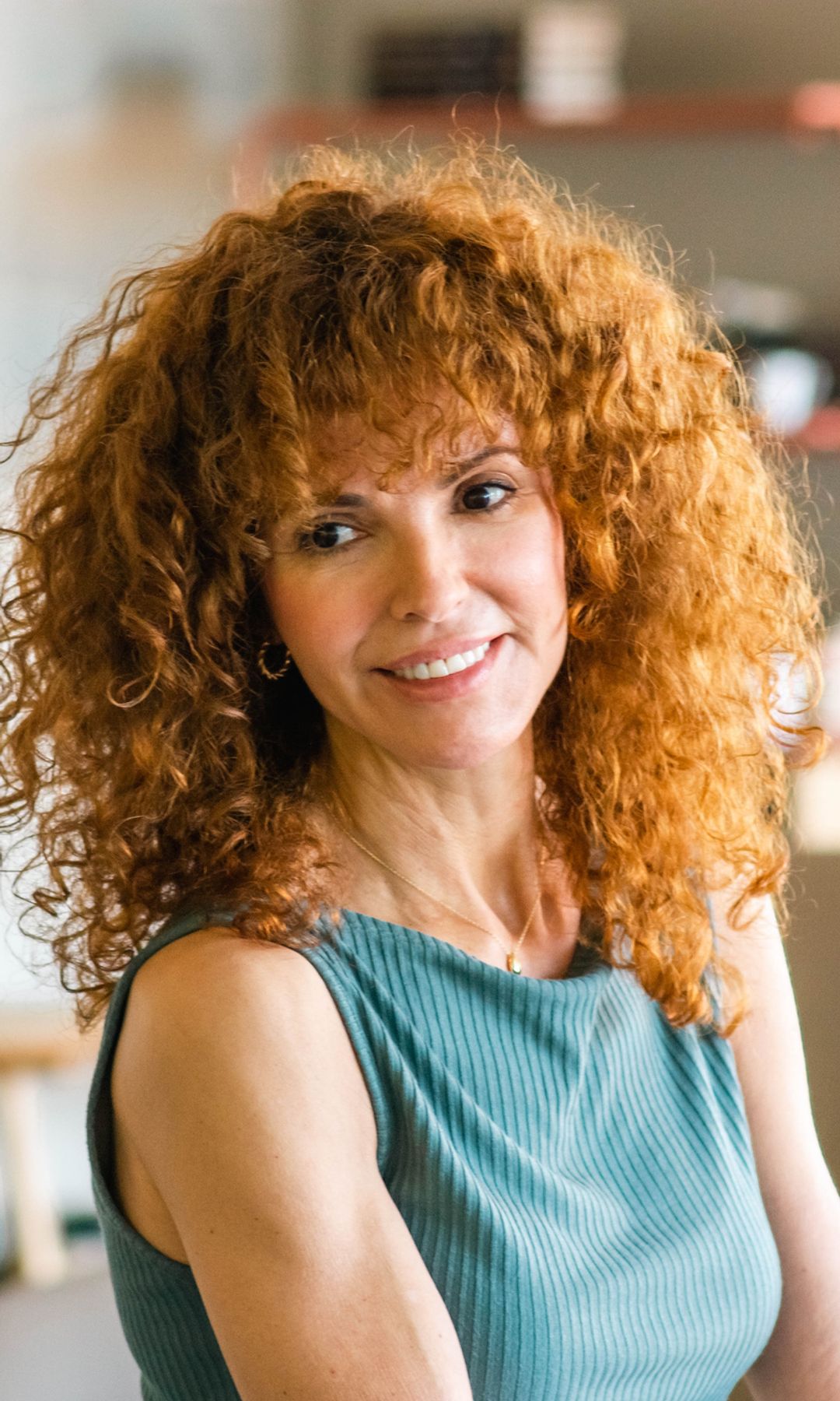 Mujer adulta con pelo rizado voluminoso y pelirrojo