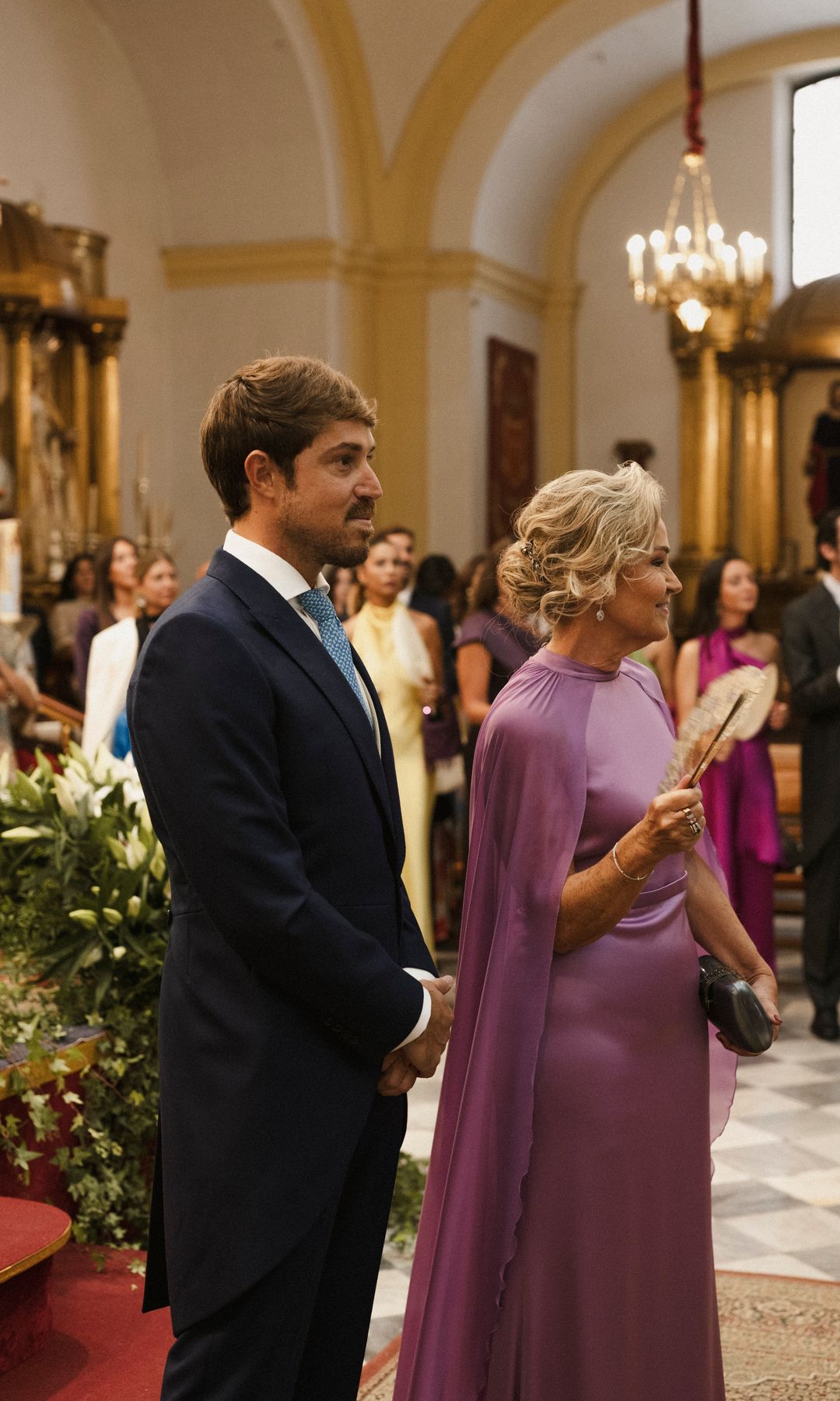 Madrina de boda con vestido satinado Elena Moore con capa