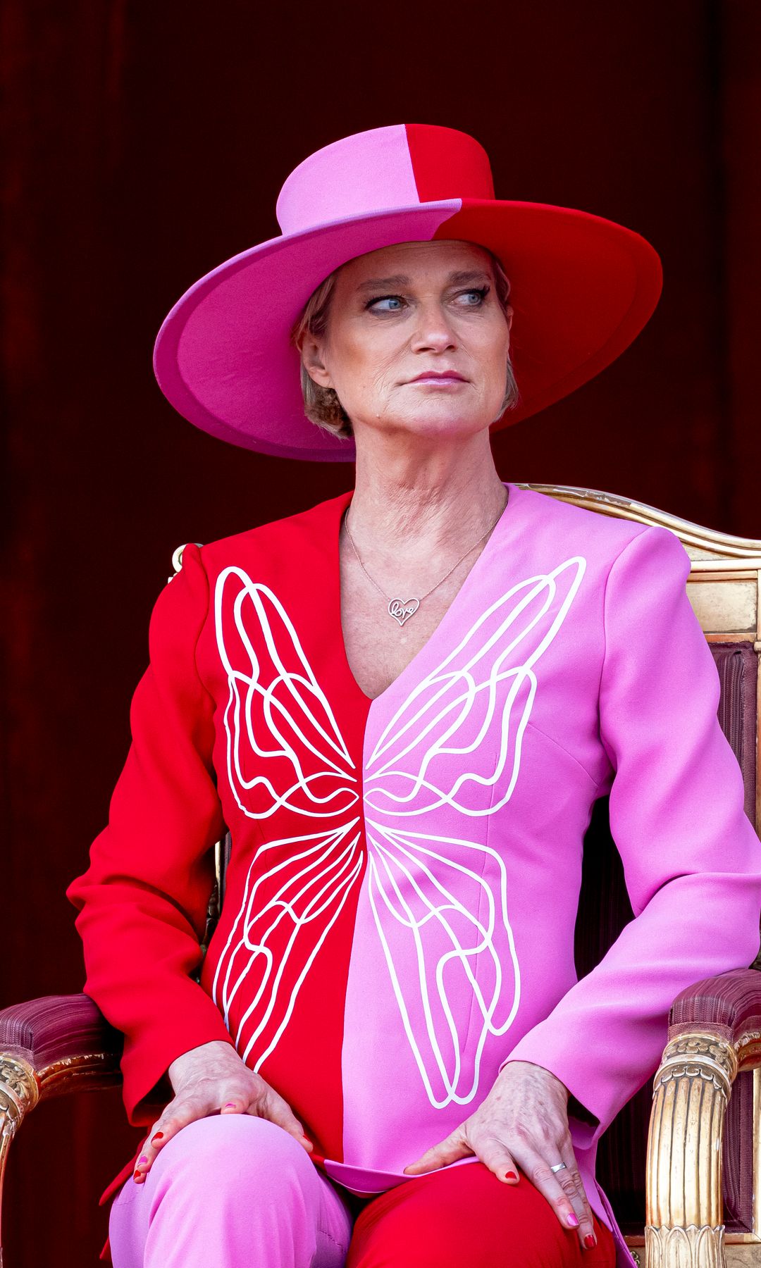 Plano medio de Delphine de Bélgica con conjunto bicolor rosa y rojo