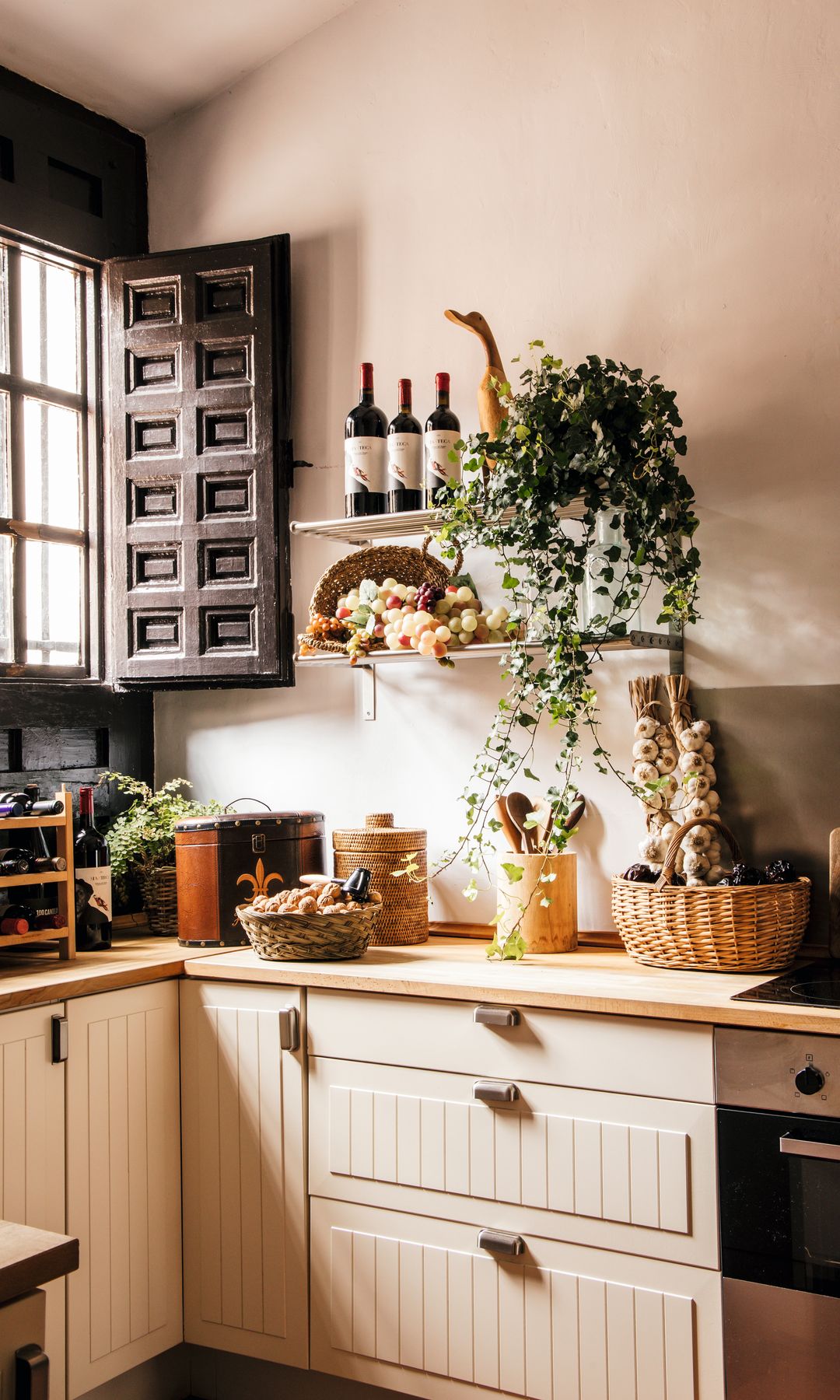 La cocina, con muebles en tonos beiges y marrón oscuro en sus ventanas 