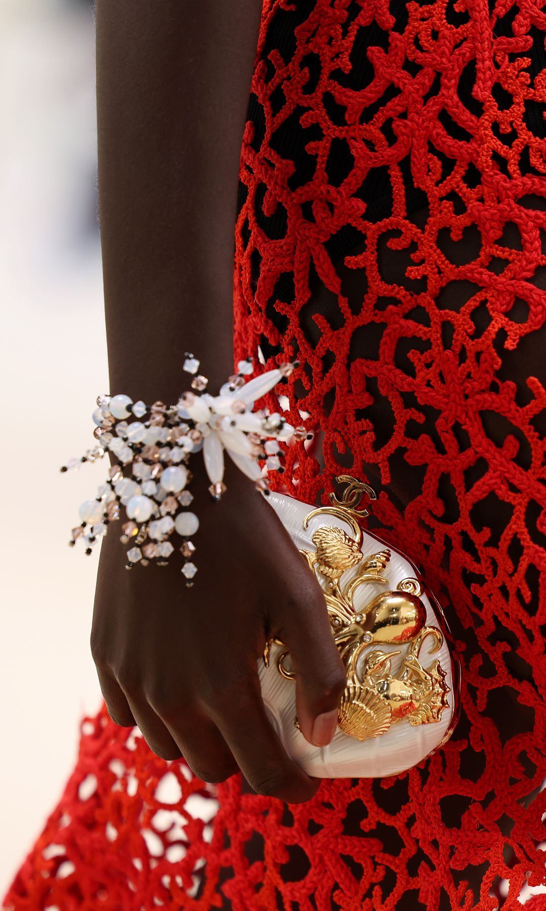 Chanel desfile Crucero 2026-2027: bolso concha con detalles marítimos dorados en relieve
