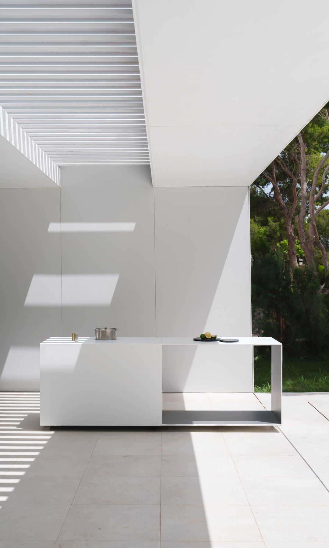Cocina de exterior blanca bajo porche blanco