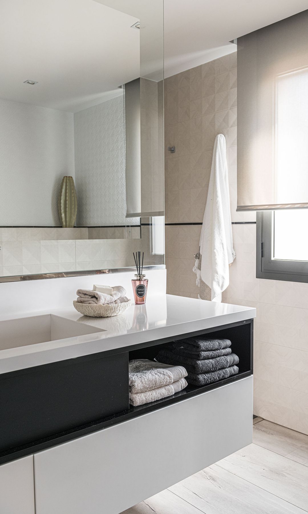 Baño con espejo Xl, mueble de baño suspendido blanco, ventana y estor, toallas