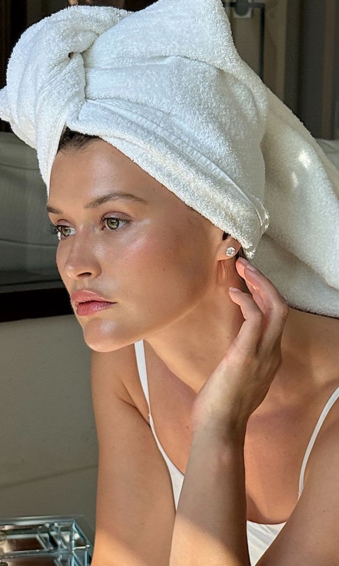 Chloe Lecareux con toalla en el pelo y pijama blanco