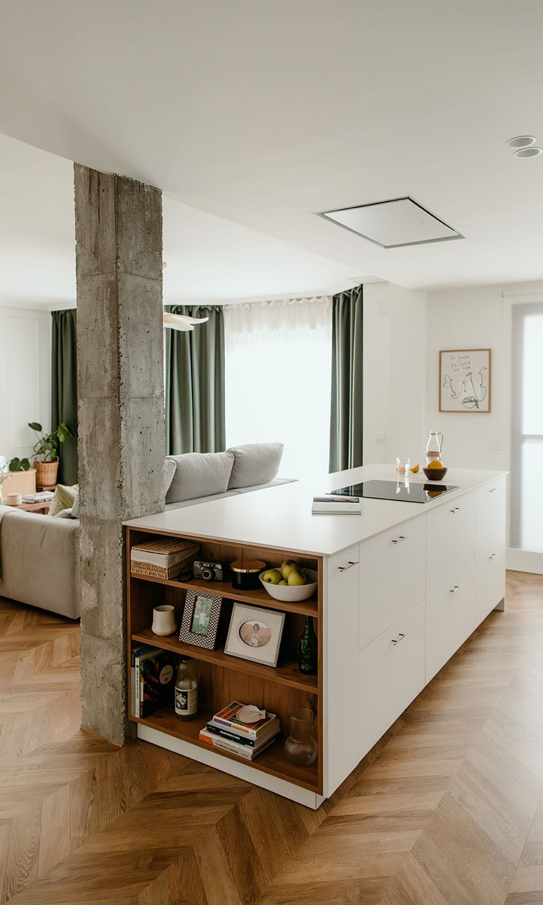 Isla de cocina con lado abierto con estantería de madera, suelo de madera en espiga y columna de hormigón