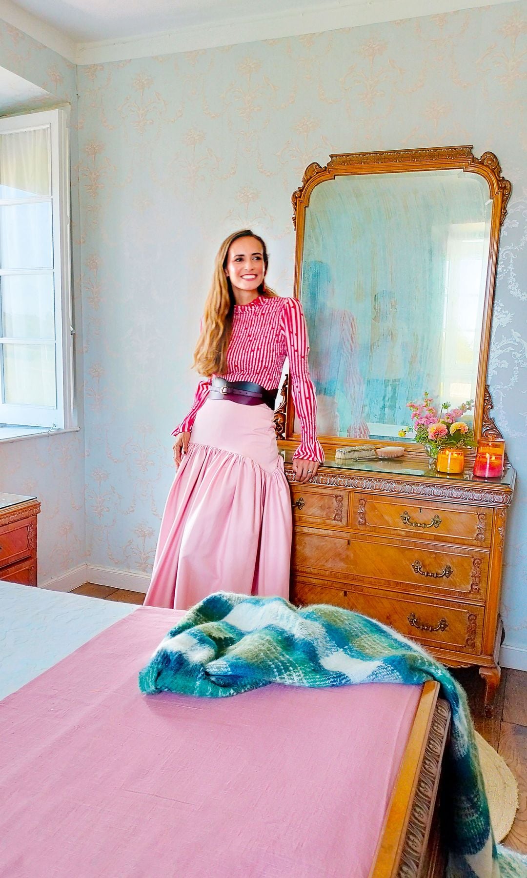 Como una princesa: Ana, en el dormitorio principal, desde el que se ve toda la finca. Los cojines y velas son de Casa Viva, y las flores, de Colmenero Atelier