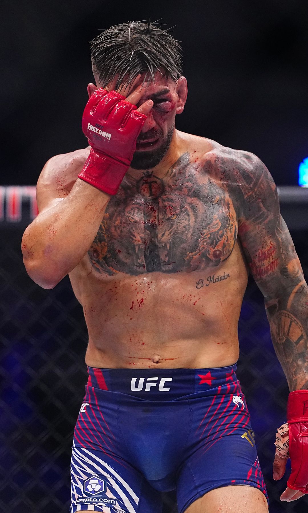 Ilia Topuria se toca la cara durante el campeonato de peso ligero de la UFC