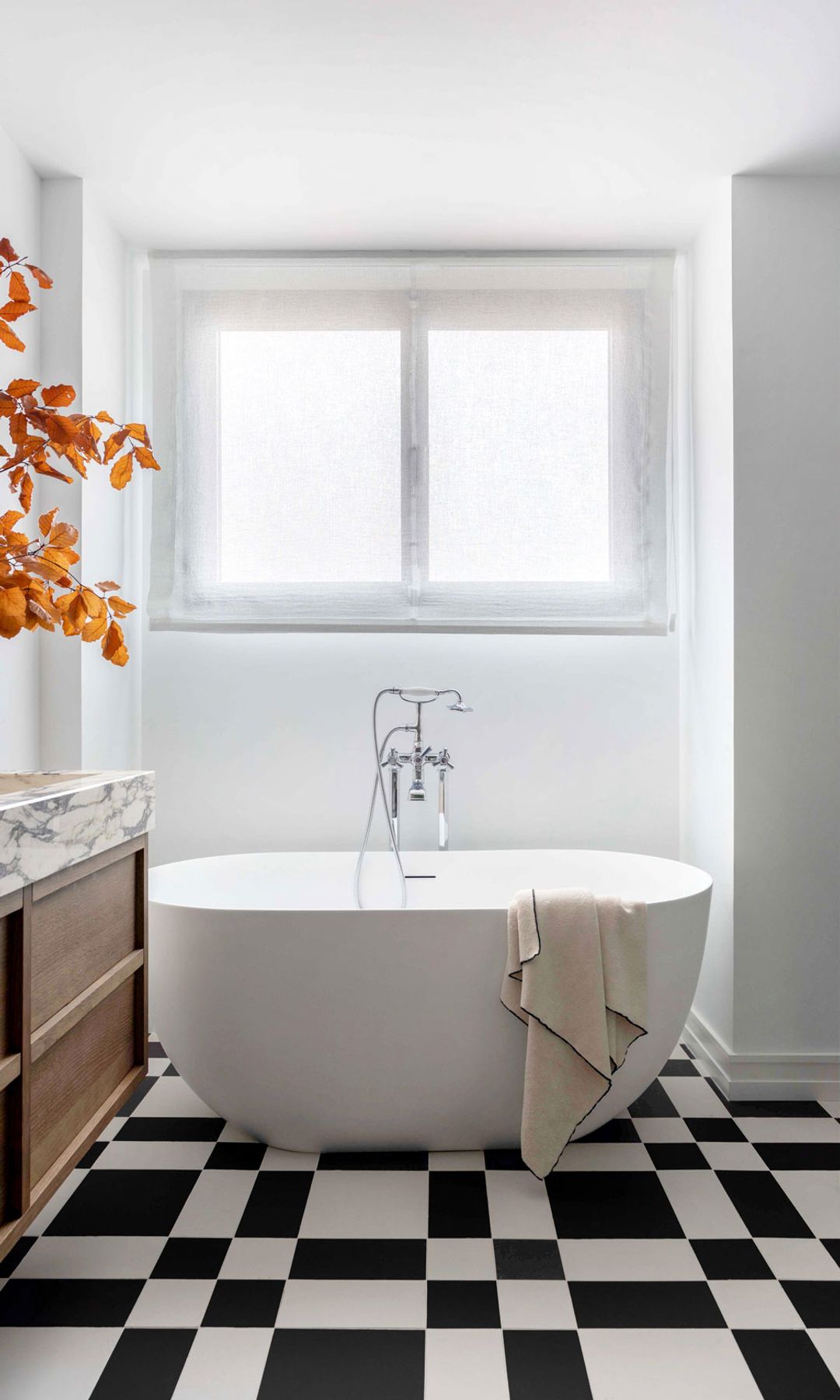 Baño con bañera y suelo en blanco y negro, diseño de Deleite Design