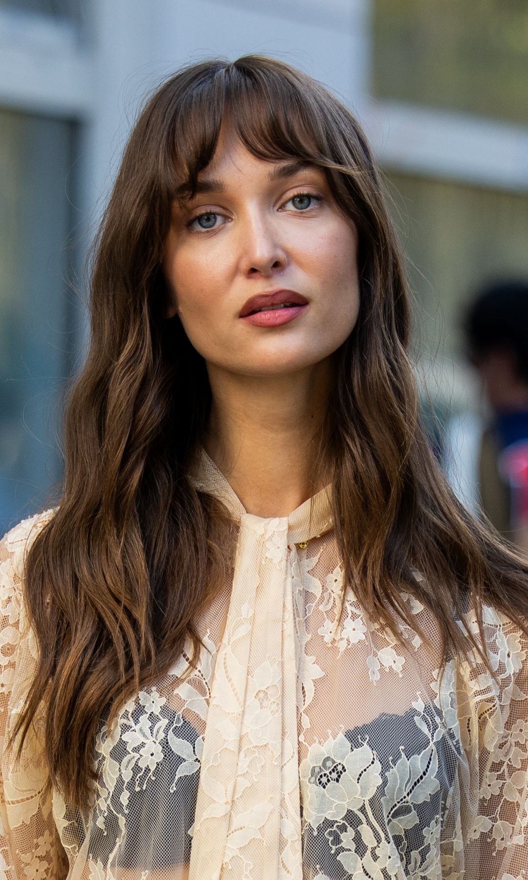 Mujer con cabello largo, flequillo y maquillaje sencillo