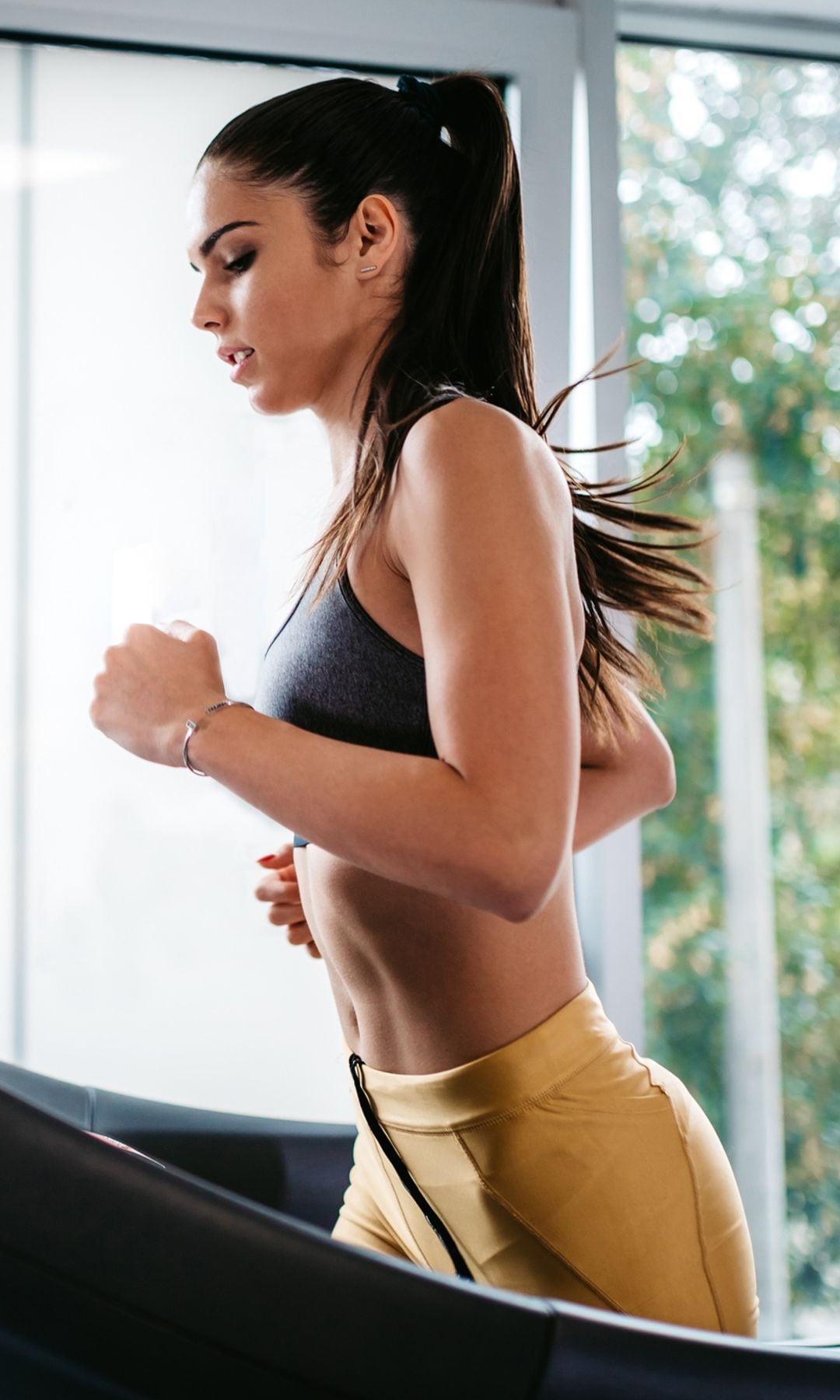 Young caucasian attractive woman running on a treadmill in a gym.