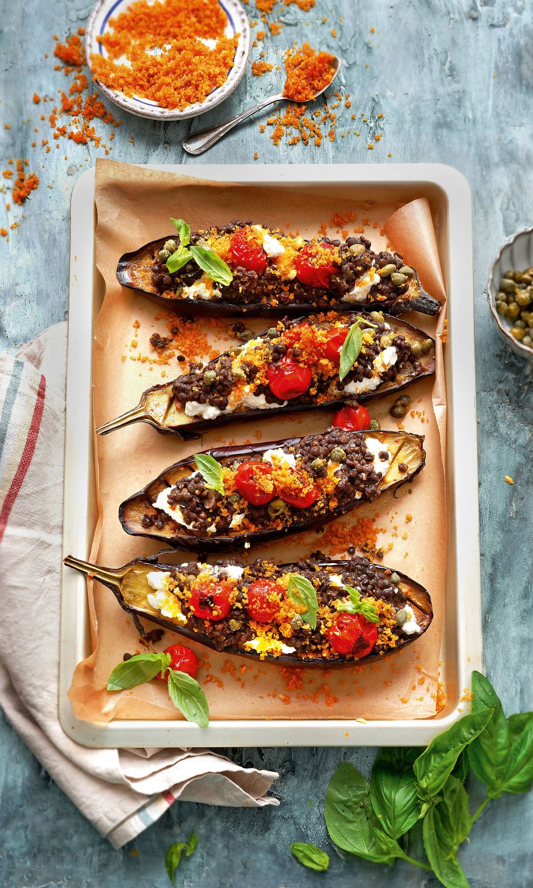 Plato de berenjenas al horno rellenas con lentejas beluga, tomate y ricotta