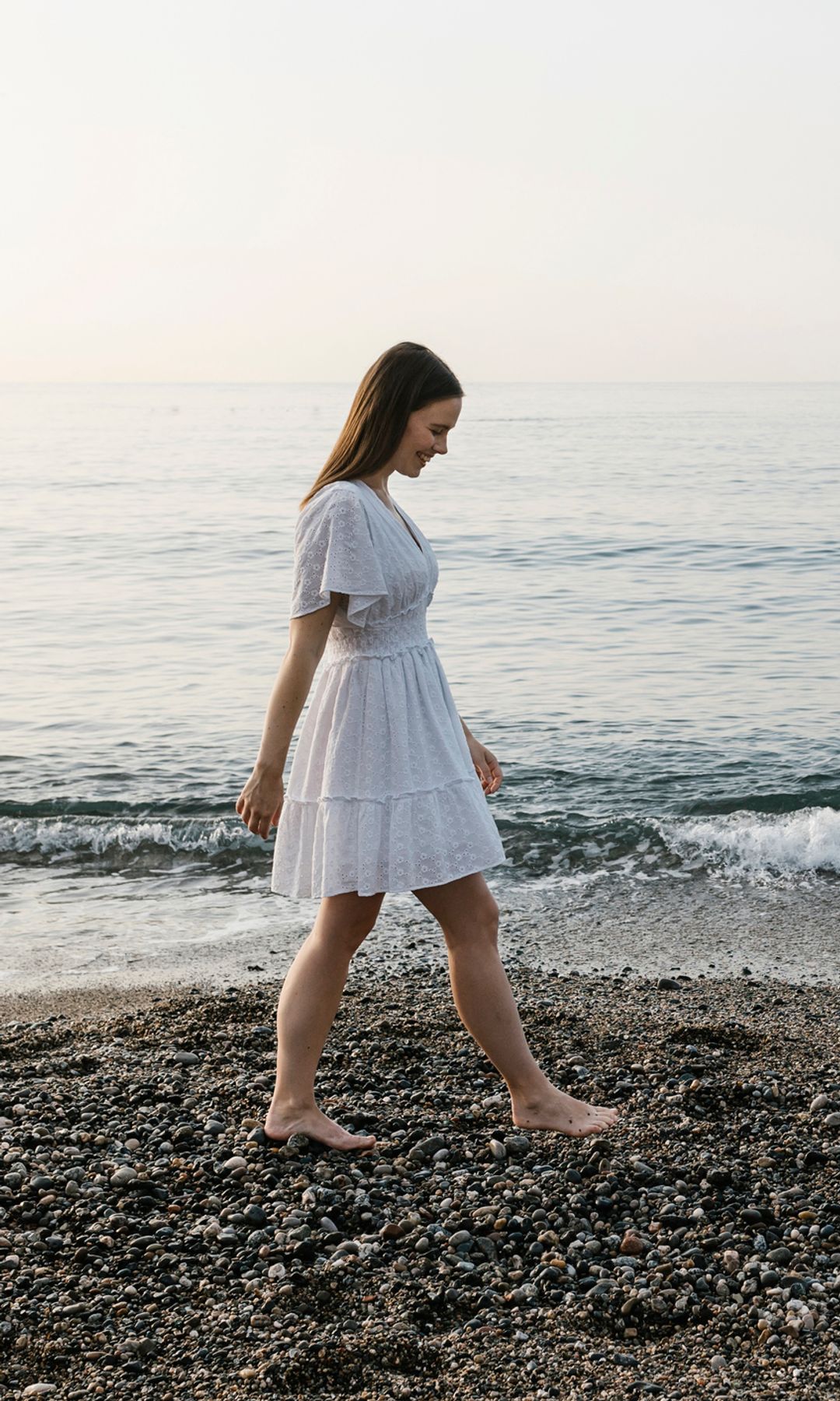 mujer relajada caminando por la playa sobre la arena
