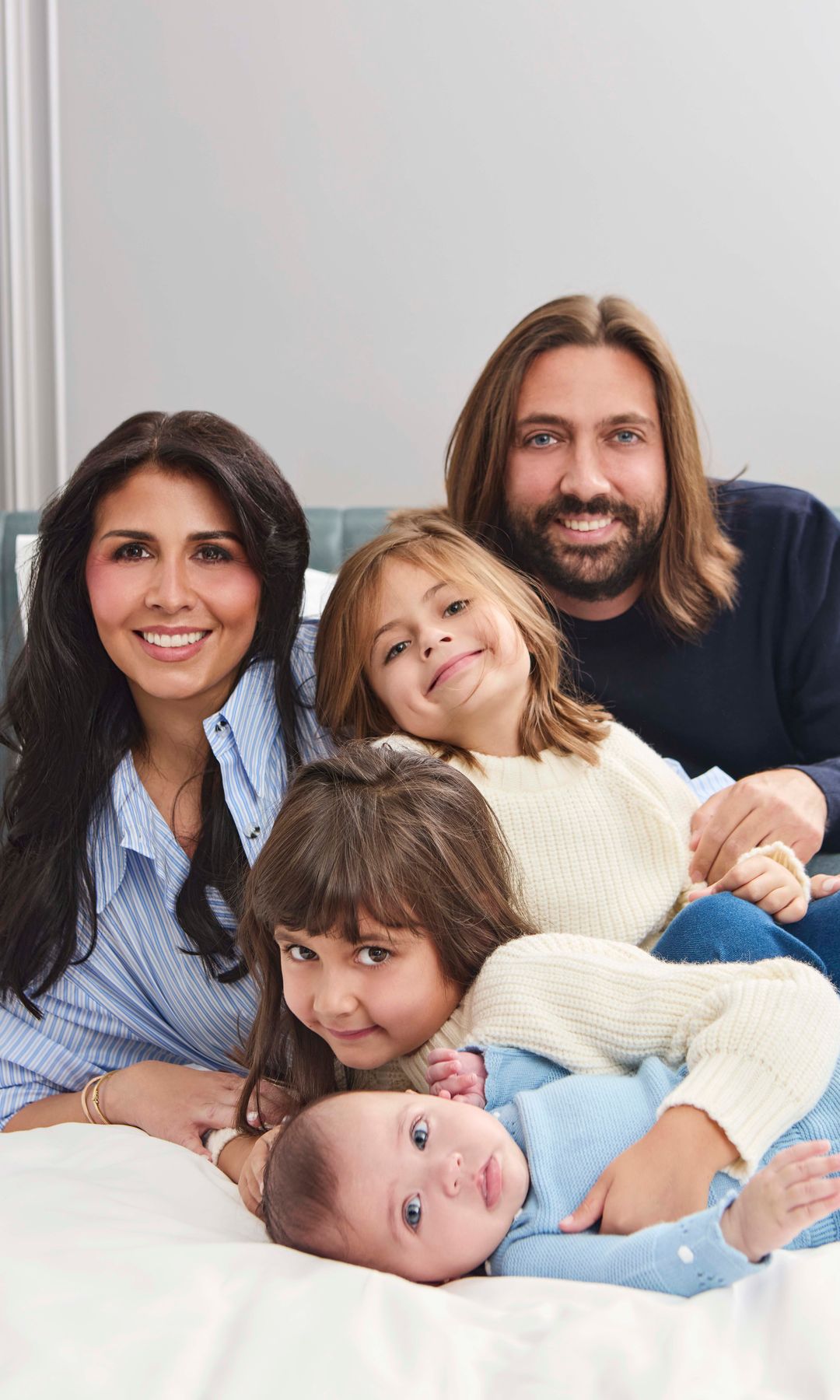 Sara Verdasco con blusa azul y Juan Carmona , con camisa negra, posan co sus hijas: niña con suéter blanco y bebé en azul