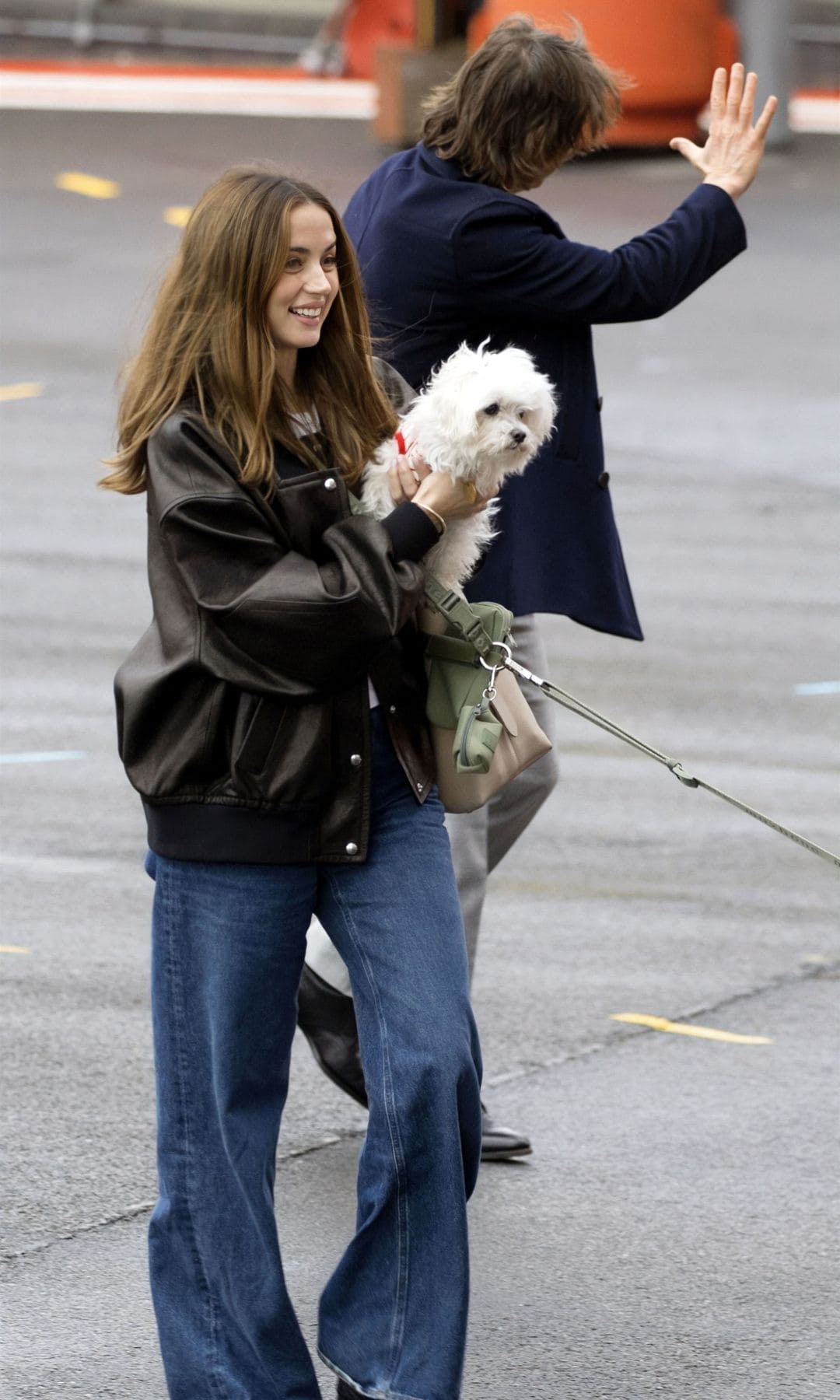 Ana de Armas con su perro en brazos y Tom Cruise saludando