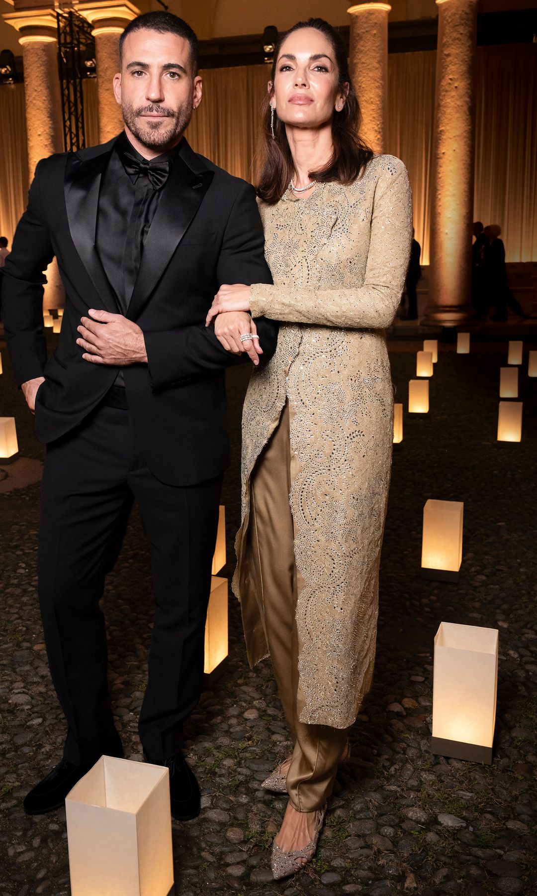 El actor Miguel Ángel Silvestre, con un "total black look" de Armani, junto a Eugenia Silva, una de sus modelos fetiche y amiga personal del diseñador, con uno de sus abrigos joya, en champán y plata