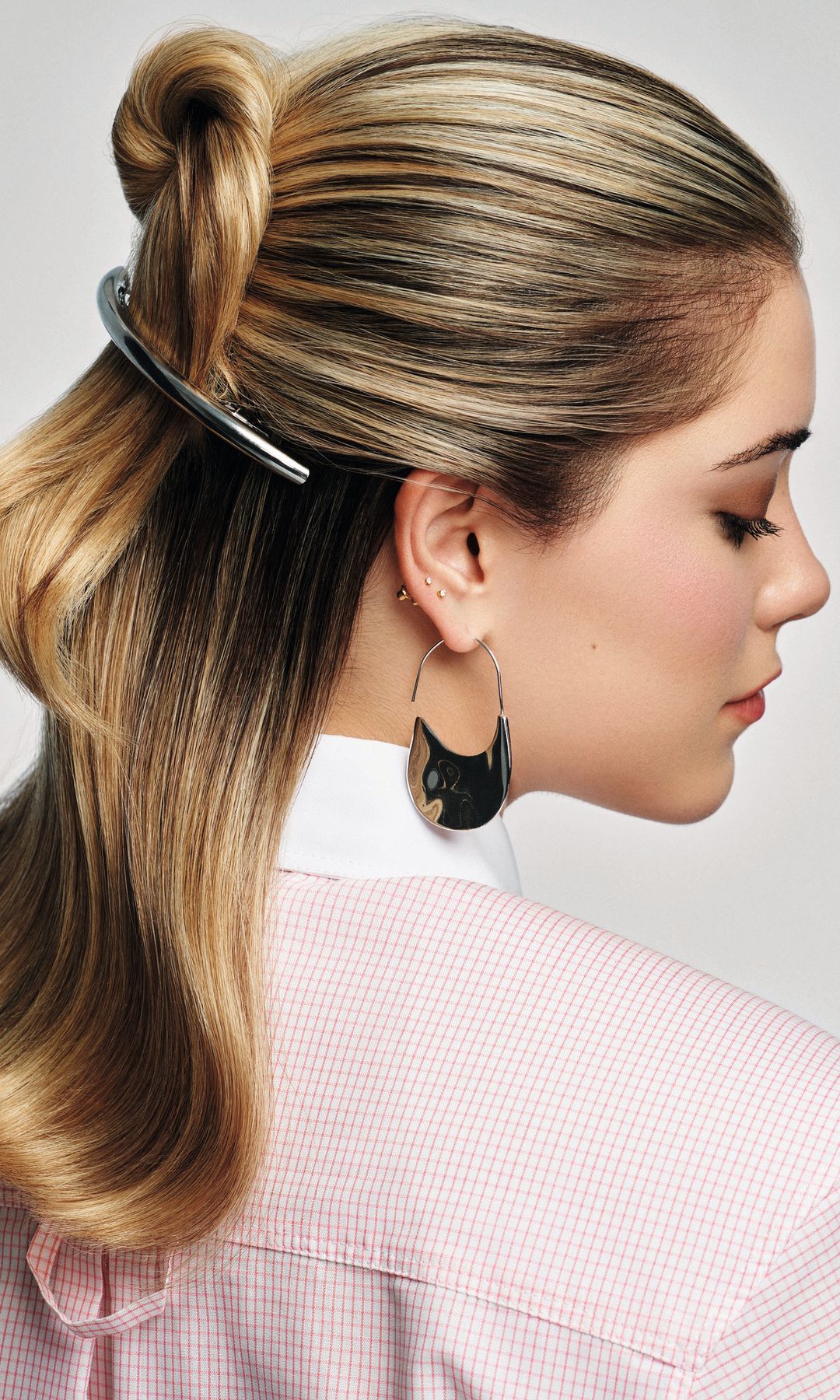 MEGAONDA Y ‘BOHO CHIC’
Martina opta por un semirrecogido de onda marcada y un retorcido que, sin ser moño, queda sujeto con el pasador (plateado para que destaque sobre el cabello rubio). “Con la tenacilla, marca una suaves ondas y péinalas con un cepillo de cerdas naturales. Aplica unas gotas extra de Glaze Drops, de Kérastase, para brillar aún más”, precisa Rodrigo Galo. En la página siguiente, con un recogido de tres trenzas, una a cada lado y otra central, adornadas con lazo azul. “Para dotar de un efecto natural pero controlado al peinado, es importante mantener a raya los baby hairs. Para ello, aplica en húmedo unas gotas de aceite; aportarán suavidad y control”.