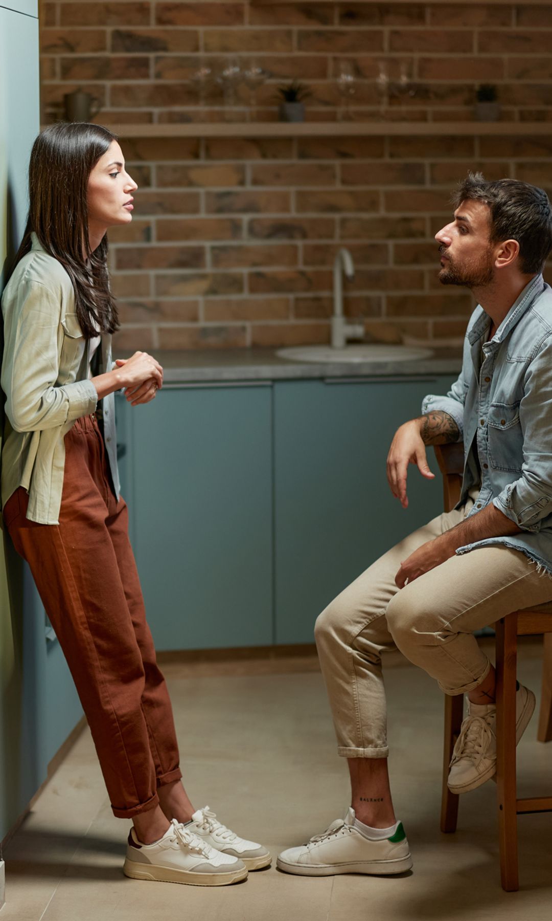 pareja joven hablando seria en la cocina