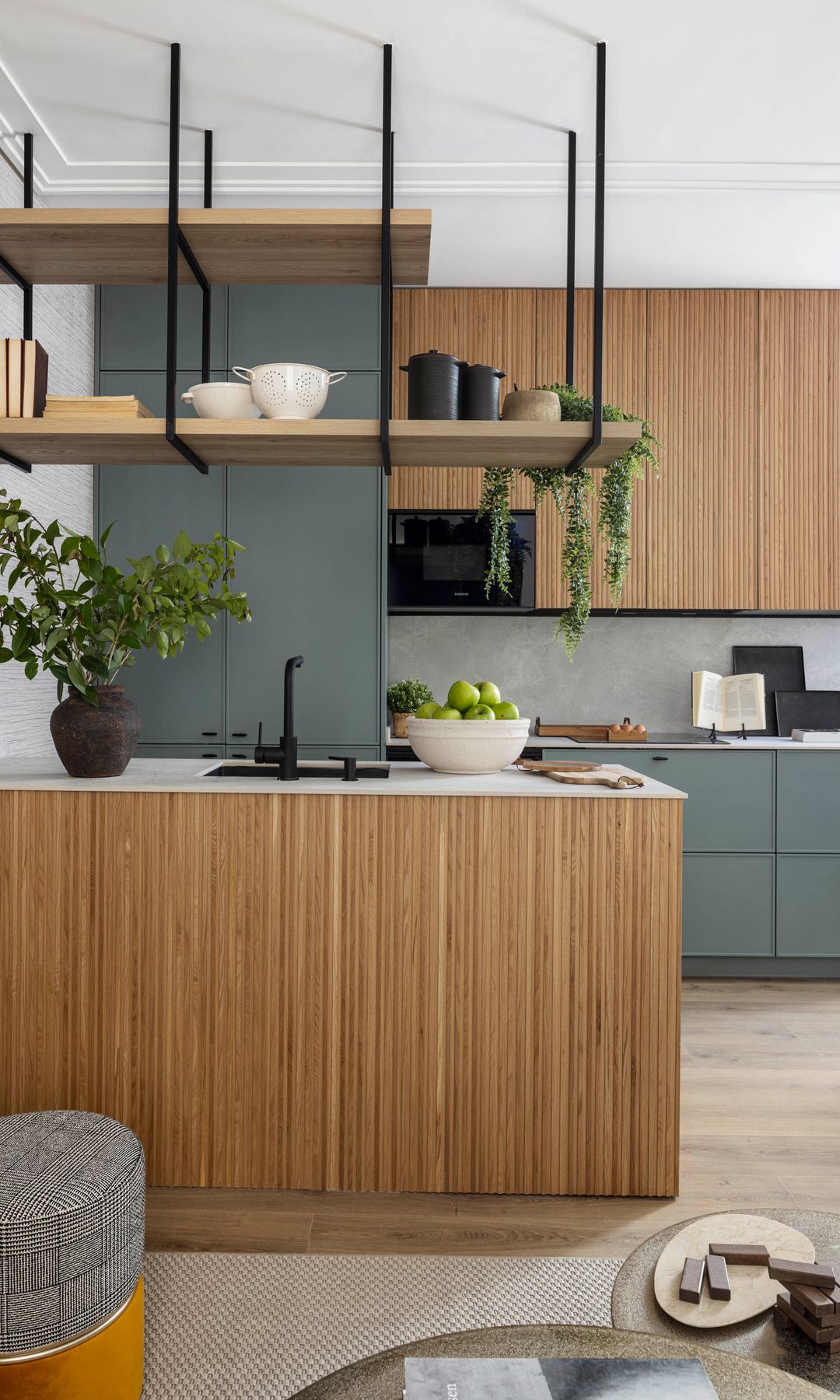 Cocina con isla de madera, estantería sobre la encimera con cazuelas y accesorios, armarios altos de madera, armarios bajos grises