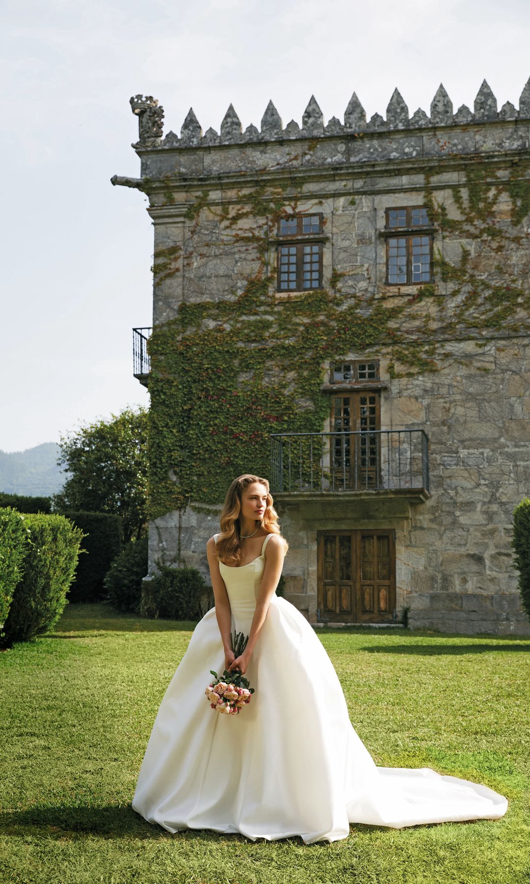 DISCRETA SENSUALIDAD
Porque ahora también luce el sol, opta por un diseño femenino y sexy, como este flamante vestido de escote encorsetado, de Rosa Clará, y gargantilla rivière, en oro blanco y diamantes, de Rabat. El bouquet es de rosas inglesas