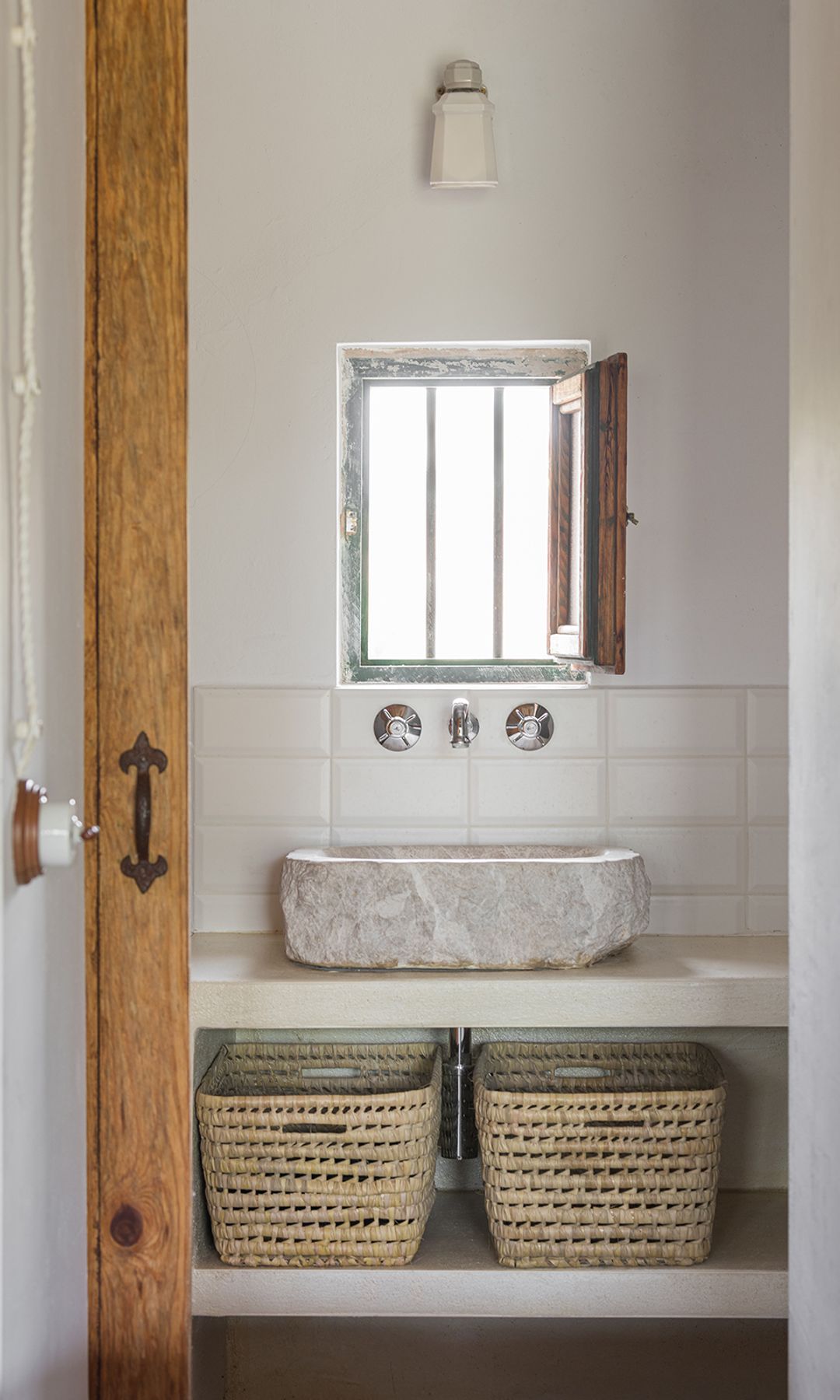 Baño sin mueble, encimera, balda con cestas, lavabo de piedra, ventana pequeña 