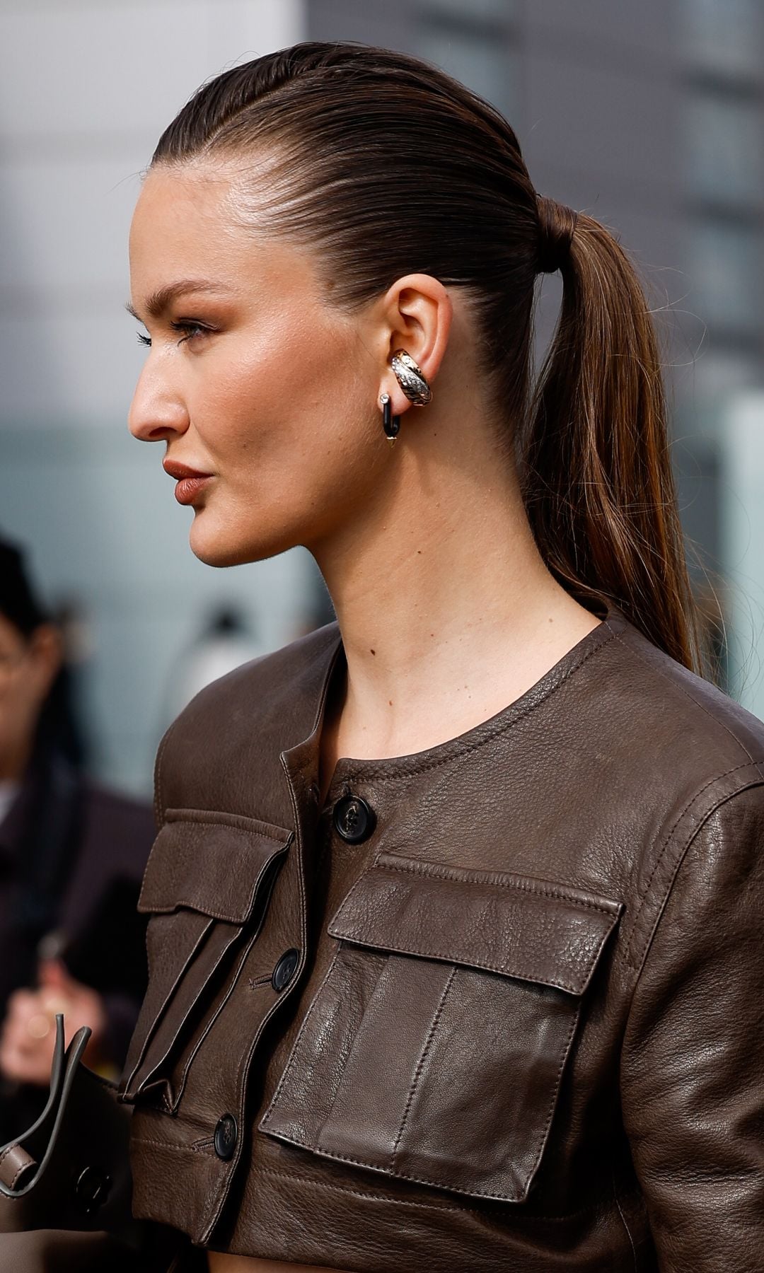 MILAN, ITALY - MARCH 01: Kristina Romanova wears brown leather crop jacket, matching skirt, brown Ferragamo bag, outside Ferragamo, during the Milan Fashion Week Womenswear Fall/Winter 2025/2026 on March 01, 2025 in Milan, Italy. (Photo by Claudio Lavenia/Getty Images)