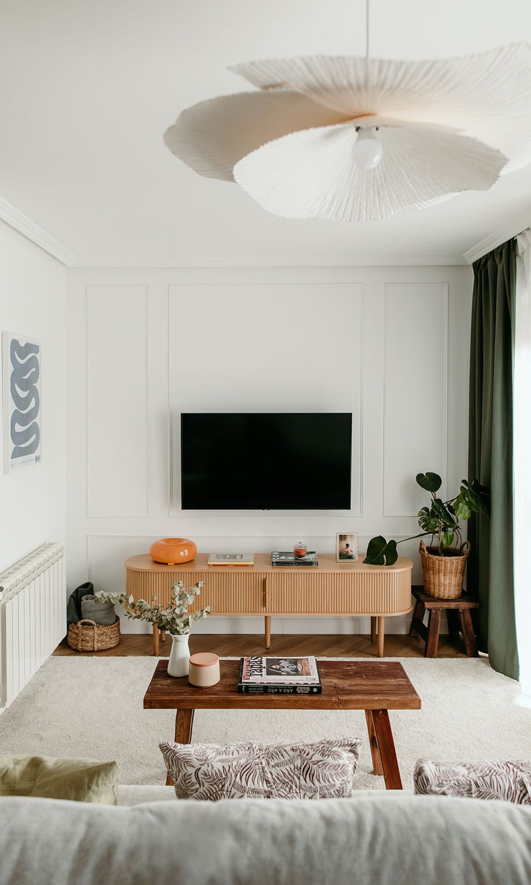 Salón con lámpara de techo, televisión en la pared, molduras decorativas, mesa de centro de madera, alfombra y aparador madera