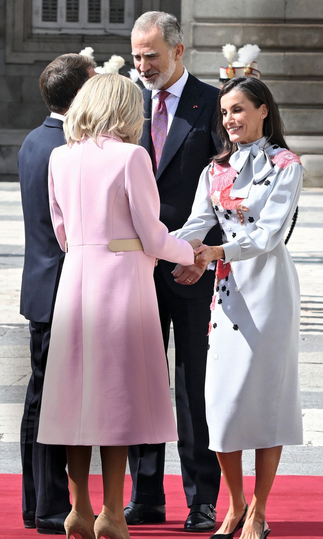 Los Reyes recibieron el 29 de septiembre con todos los honores a Emmanuel Macron y a su esposa, Brigitte —con abrigo rosa de Louis Vuitton— en el Patio de Armas del Palacio Real. Para este primer encuentro, la Reina eligió el vestido de Pertegaz —la firma que la vistió de novia— con lazada al cuello y bordados florales, que estrenó en el debut de su hija Leonor en los Premios Princesa de Asturias (2019).