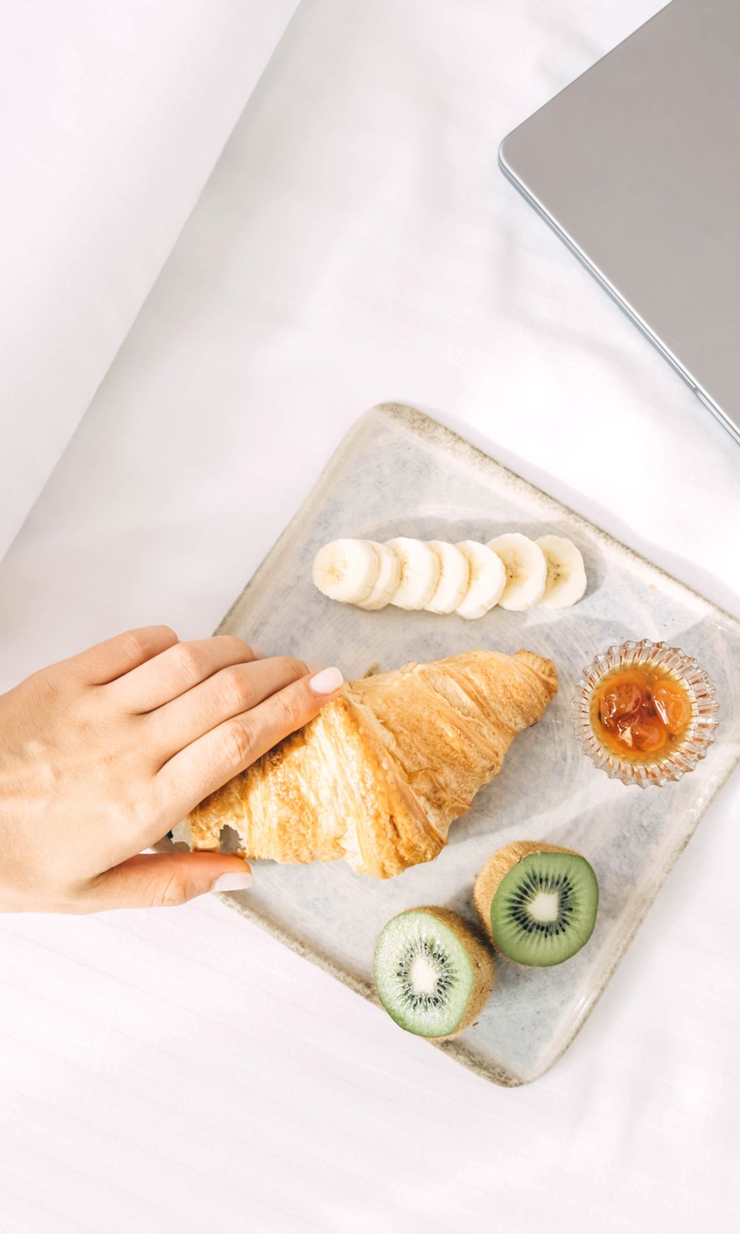 Desayuno minimalista con croissant platano y kiwi