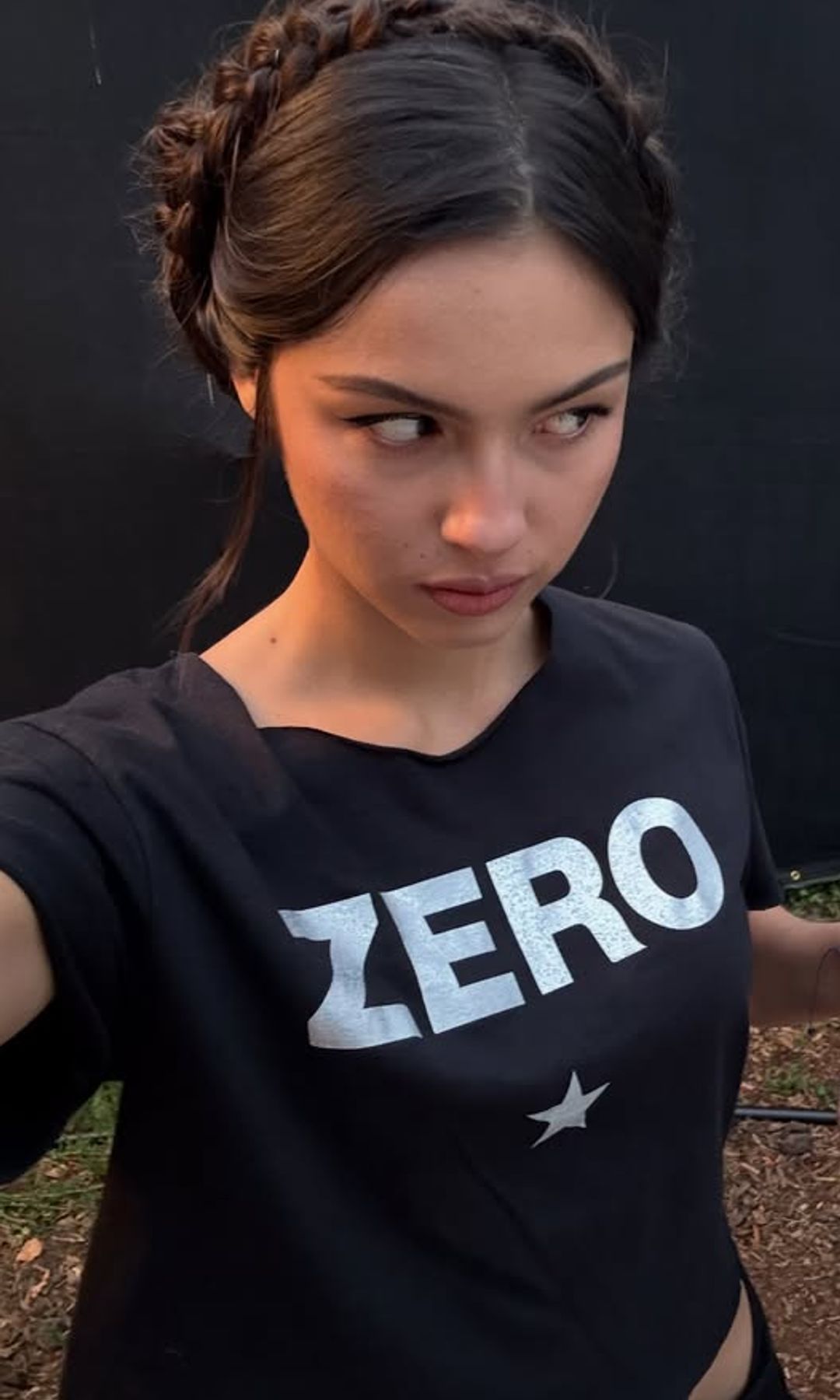 Olivia Rodrigo con trenza corona de acabado relajado y mechones sueltos alrededor del rostro