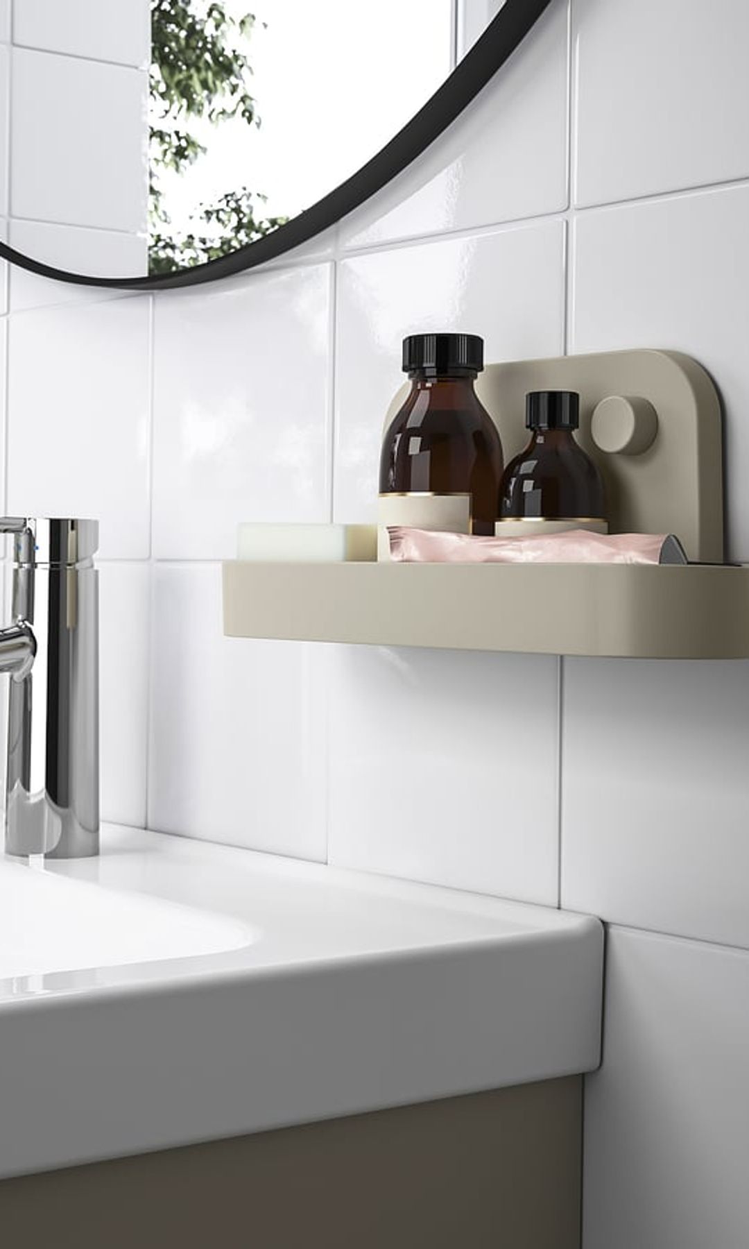 Baño con azulejos blancos, espejo redondo, estante de pared con botes