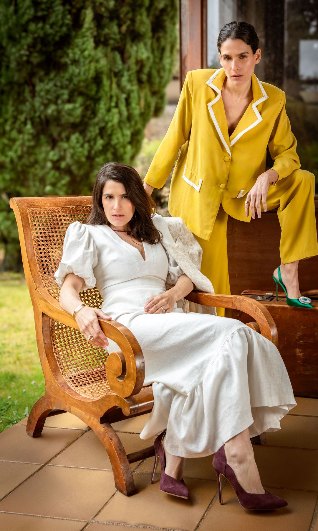 Inés posa con traje de chaqueta de color mostaza, de Inma Linares, y zapatos de Aquazzura, y Lucía, con vestido y chaqueta de Martín Alcalde Studio, zapatos de Lili & You y pulseras de Dinh Van.