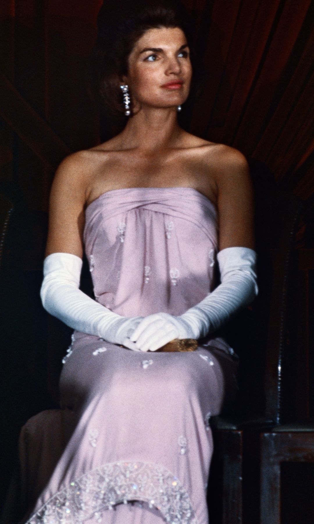 Un primer plano de la primera dama Jacqueline Kennedy, enfundada en un vestido de noche sin tirantes y guantes hasta el codo