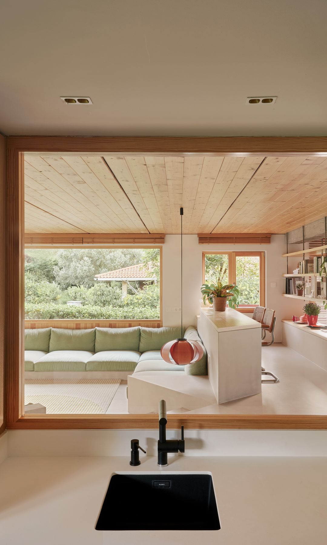 Cocina con tabique de cristal con marco de madera con vistas al salón 