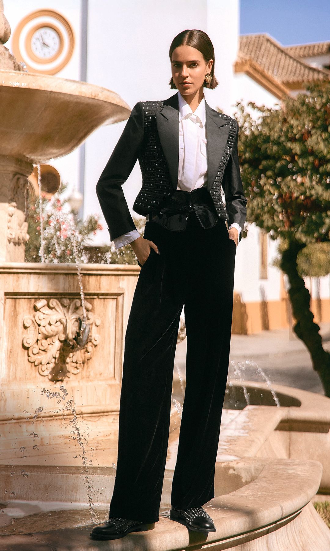 TYPICAL 
SPANISH
Lucía Avilés posa con total look, de Emporio Armani, y pendientes, de Singularu, junto a la fuente de la Plaza de los Jardines, de Dos Hermanas. 