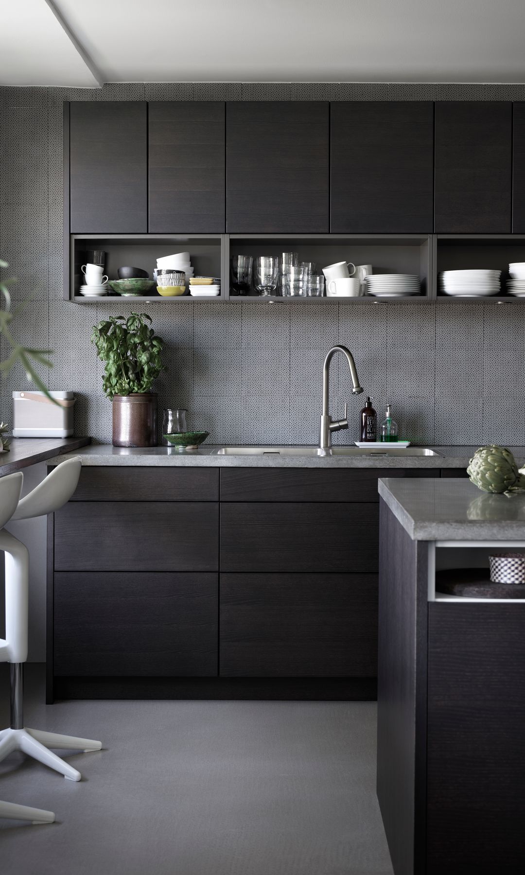 Cocina negra con azulejos grises, suelo gris, barra junto a la ventana, taburetes altos 