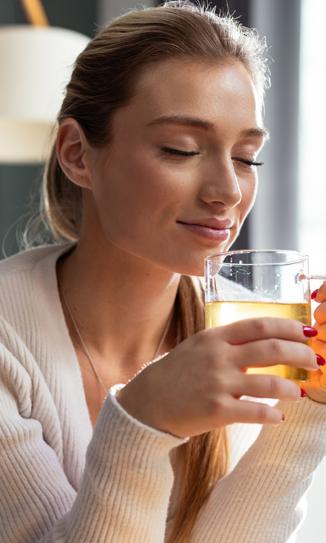 Mujer serena tomando una infusión de jengibre y cúrcuma
