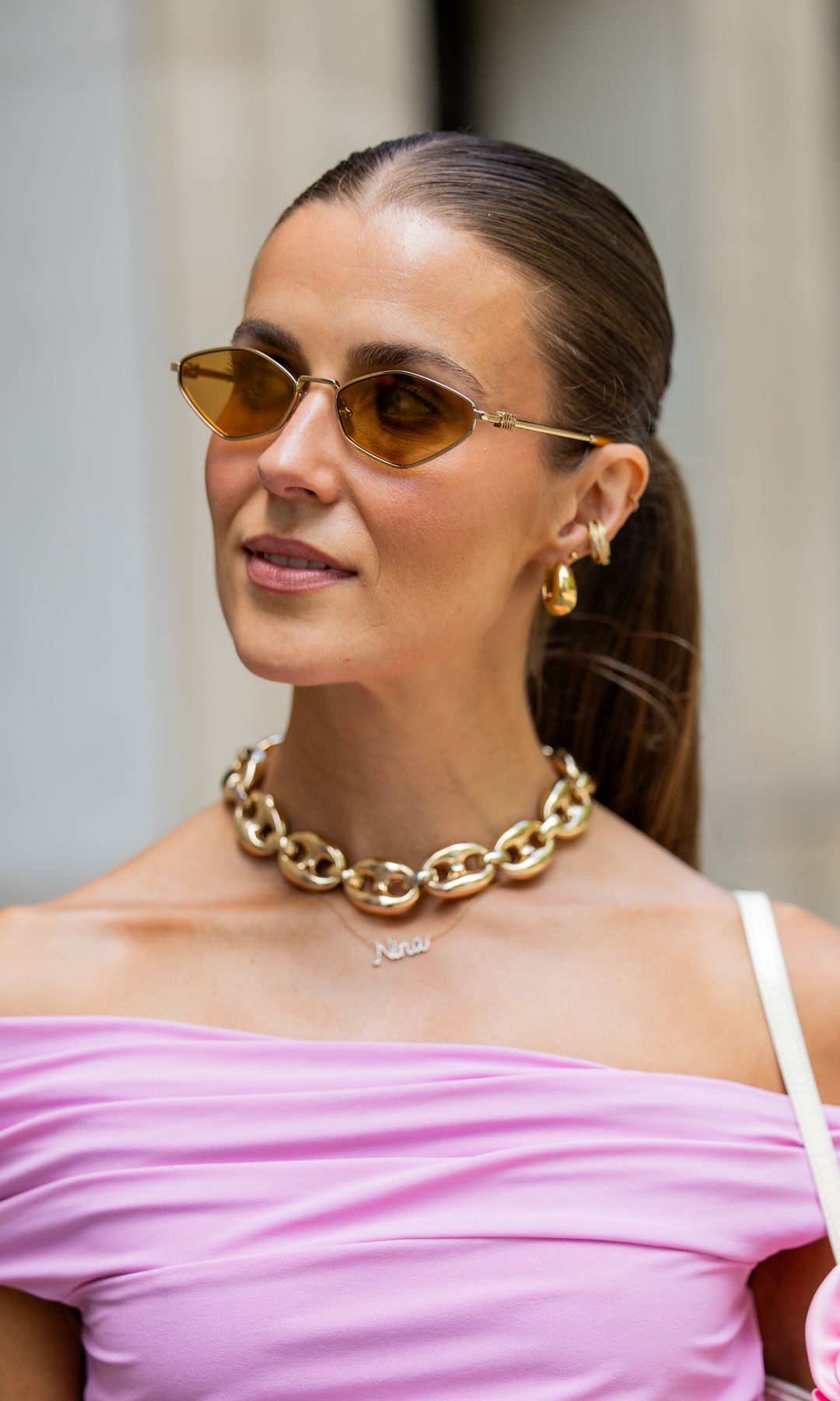 BARCELONA, SPAIN - JUNE 29: Nina Sandbech wears pink off shoulder top Zara, sunglasses Miu Miu, golden necklace on June 29, 2024 in Barcelona, Spain