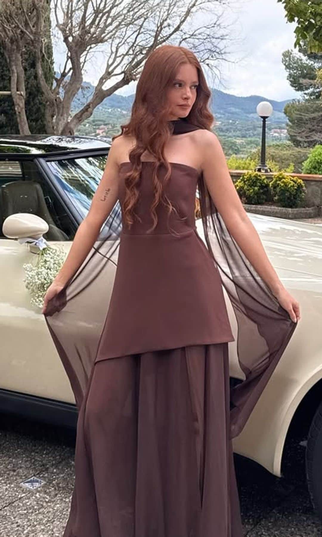 Invitada con vestido marrón con capa