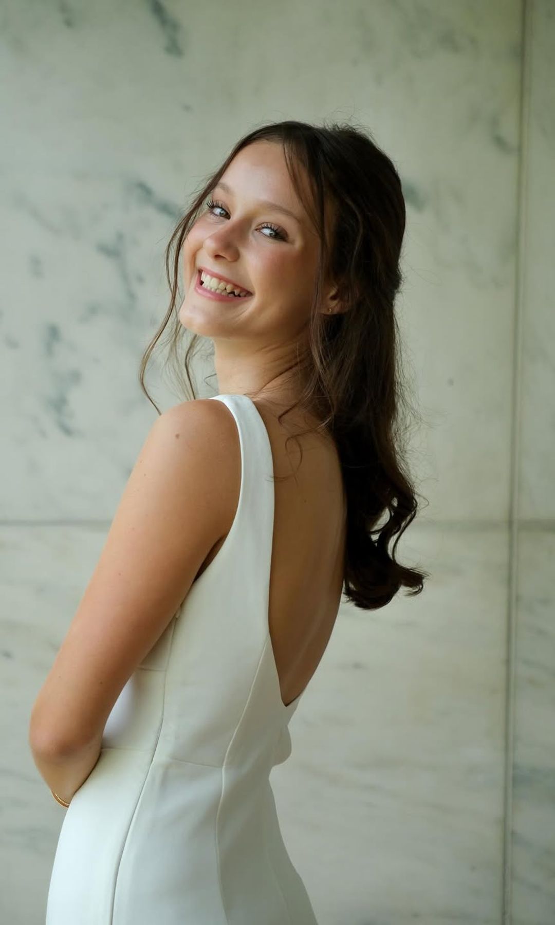 La joven con un bonito vestido blanco con gran escote en la espalda