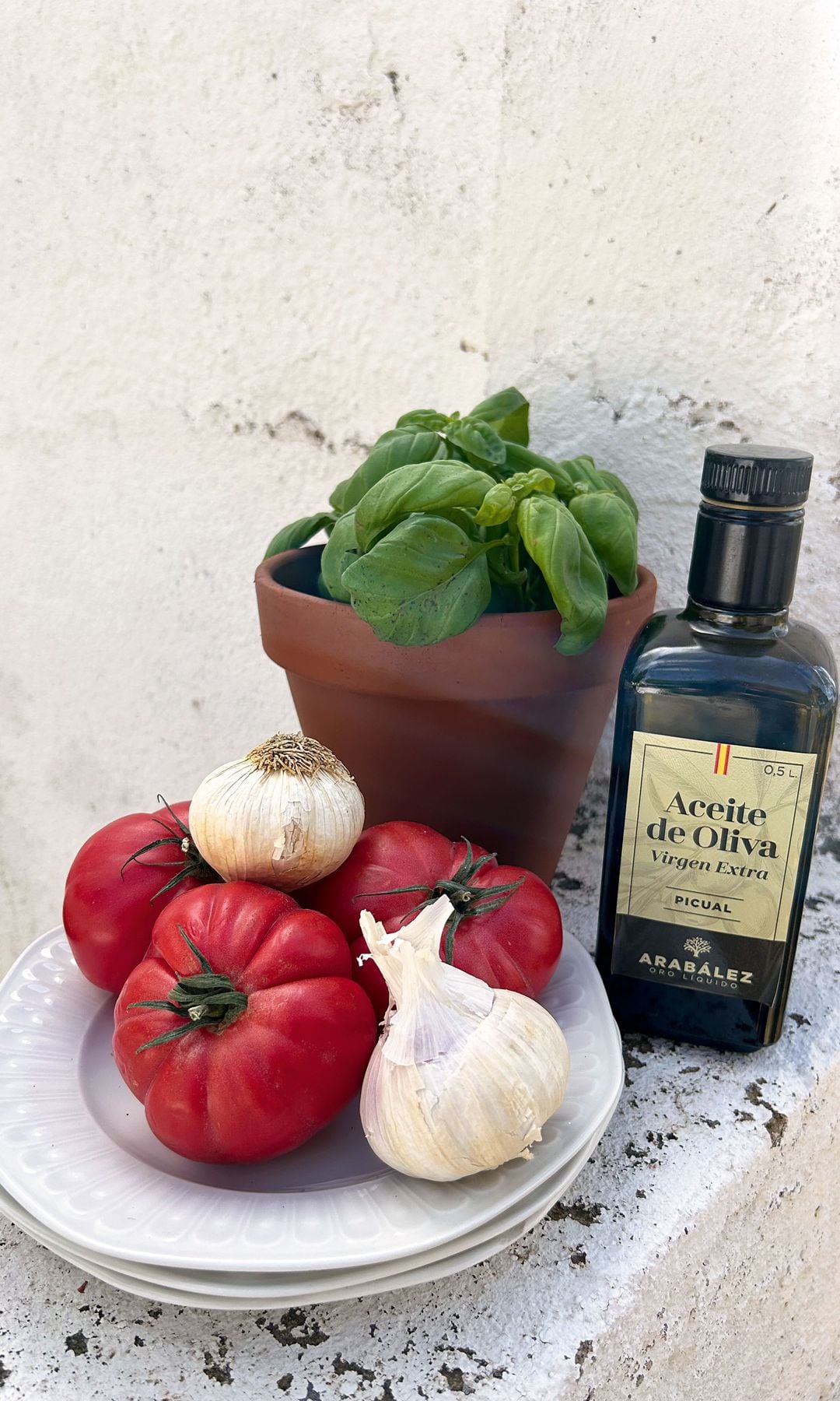 BODEGÓN CON DENOMINACIÓN
Aceite de oliva virgen extra Arabález, un par de cabezas de ajos, tomates frescos y una planta de albahaca