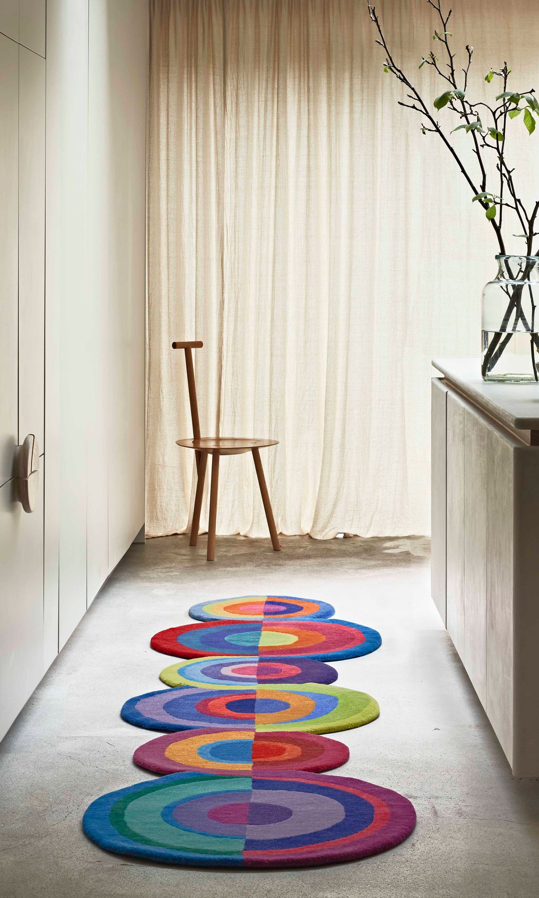 Cocina con armarios en tonos beiges y alfombra de formas redondeadas y colores brillantes 